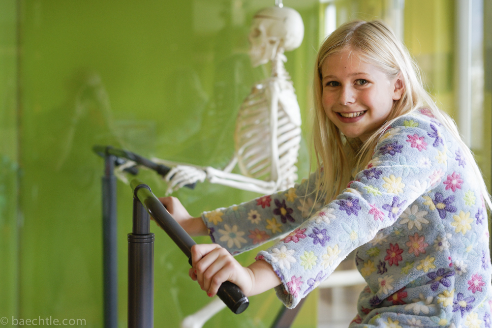 Welche Knochen bewegen sich wie beim Radfahren? Das radelnde Skelett im Hintergrund zeigt es.